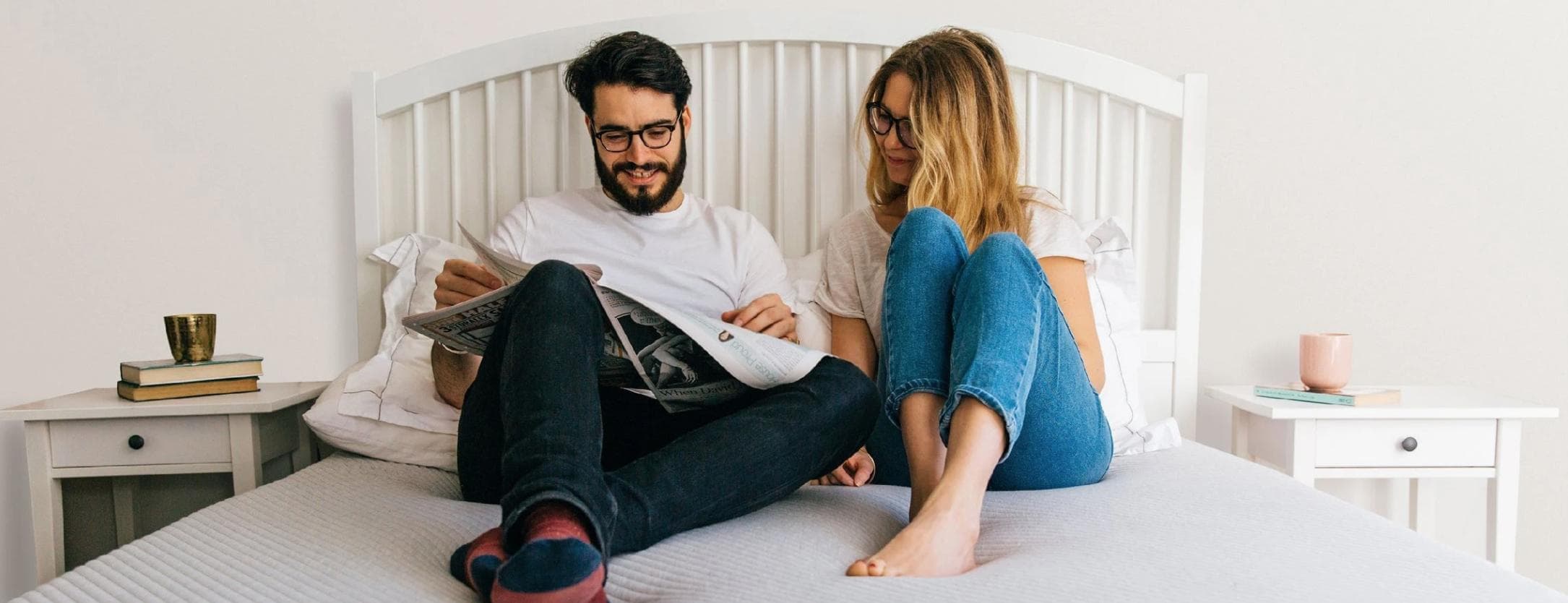 A couple reading a newspaper together on their Leesa bed