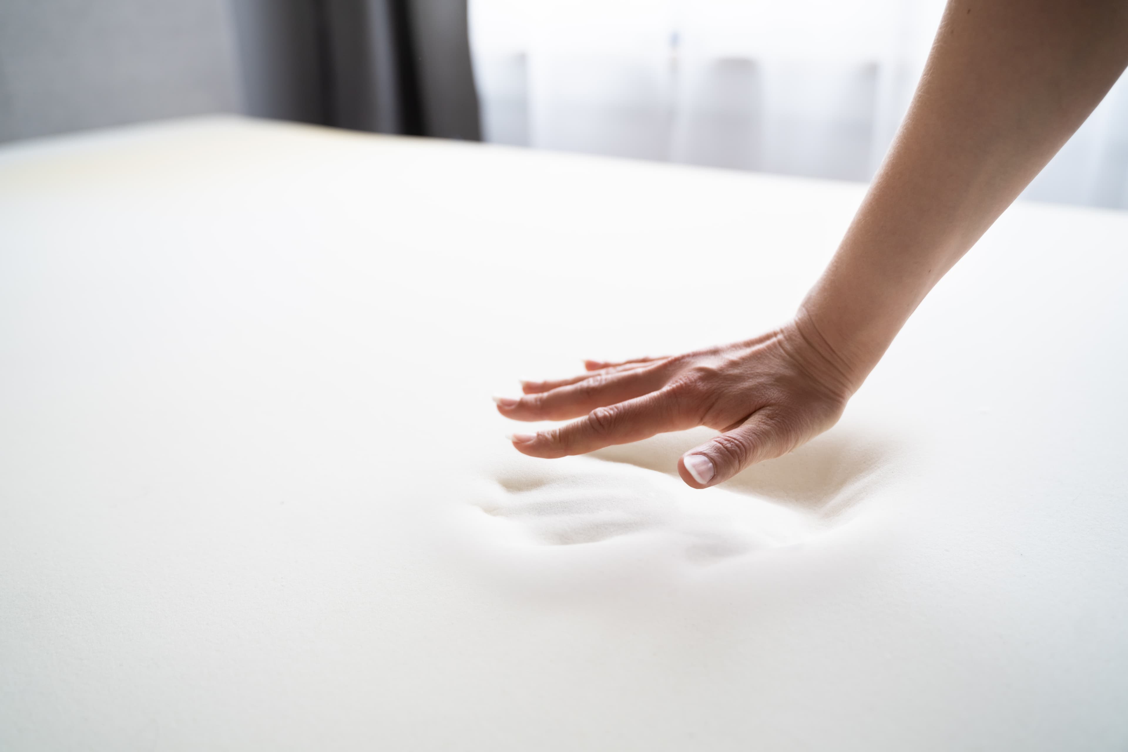 A man testing the memory foam of a Leesa mattress