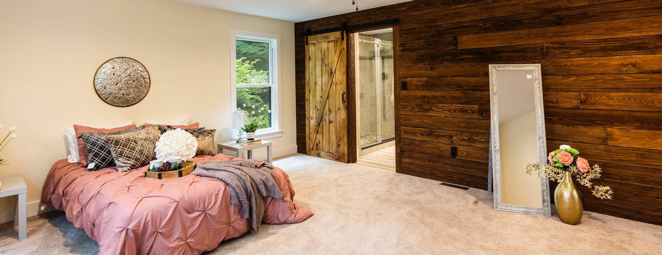 A Leesa mattress in a pink, cream, and brown wood decorated room.