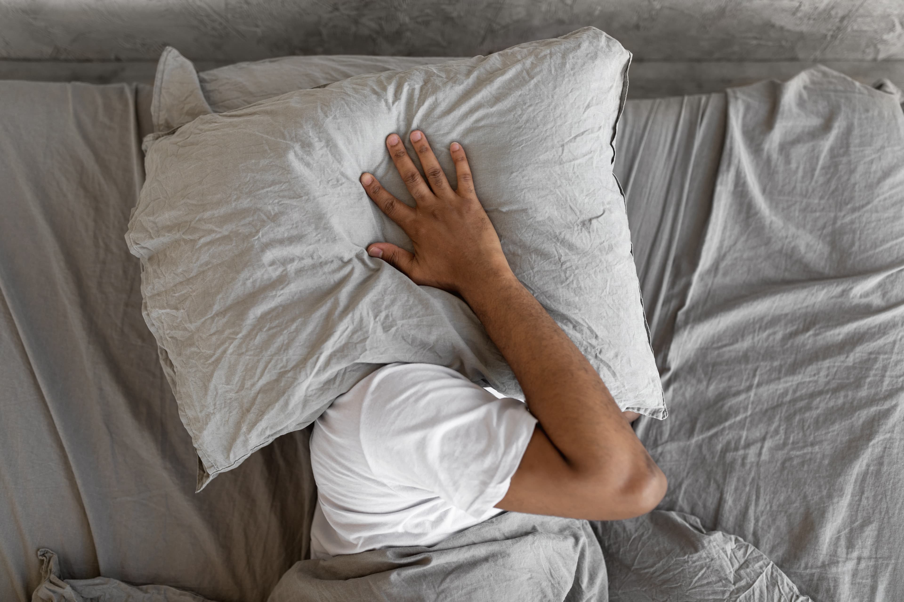 A guy hiding under a Leesa pillow